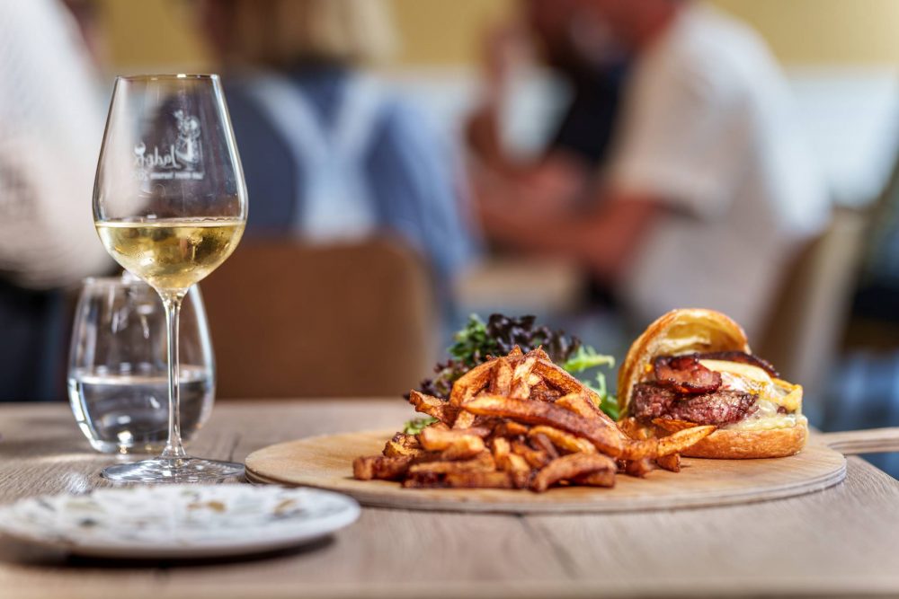 Table dressée avec burger, frites maison et vin blanc au restaurant Bistrot de l'O